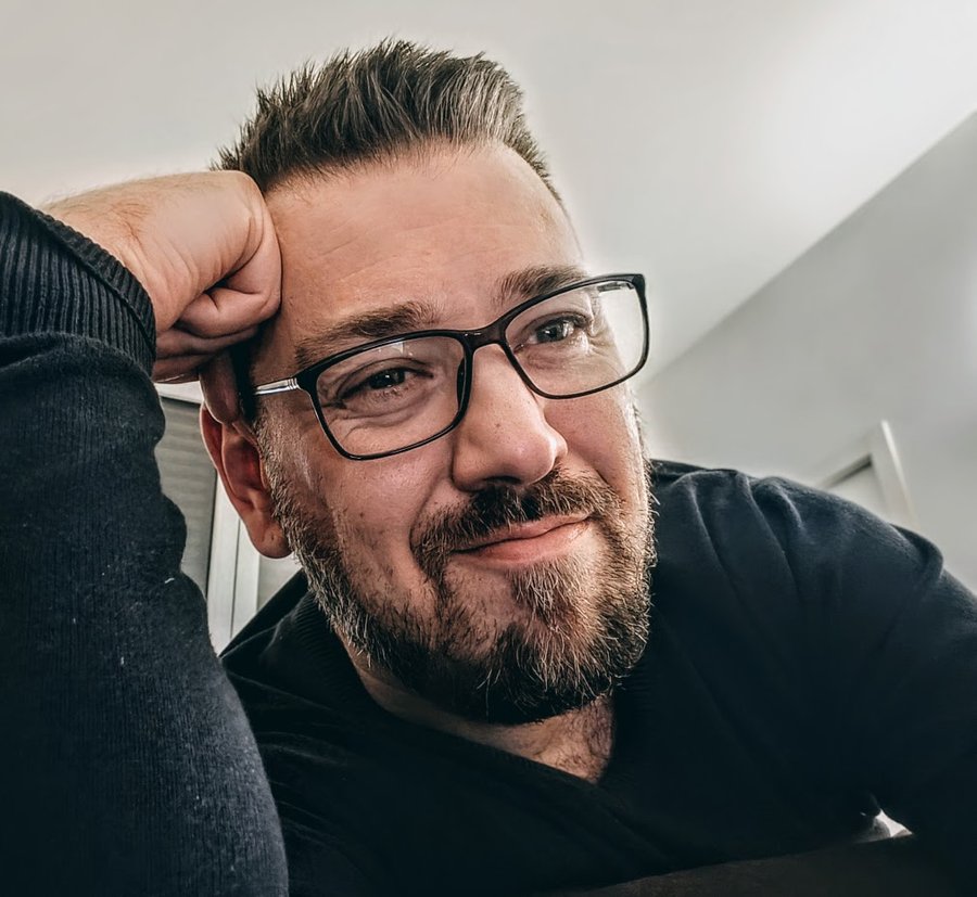 Matt Bedford — smiling, glasses, resting his head on his hand